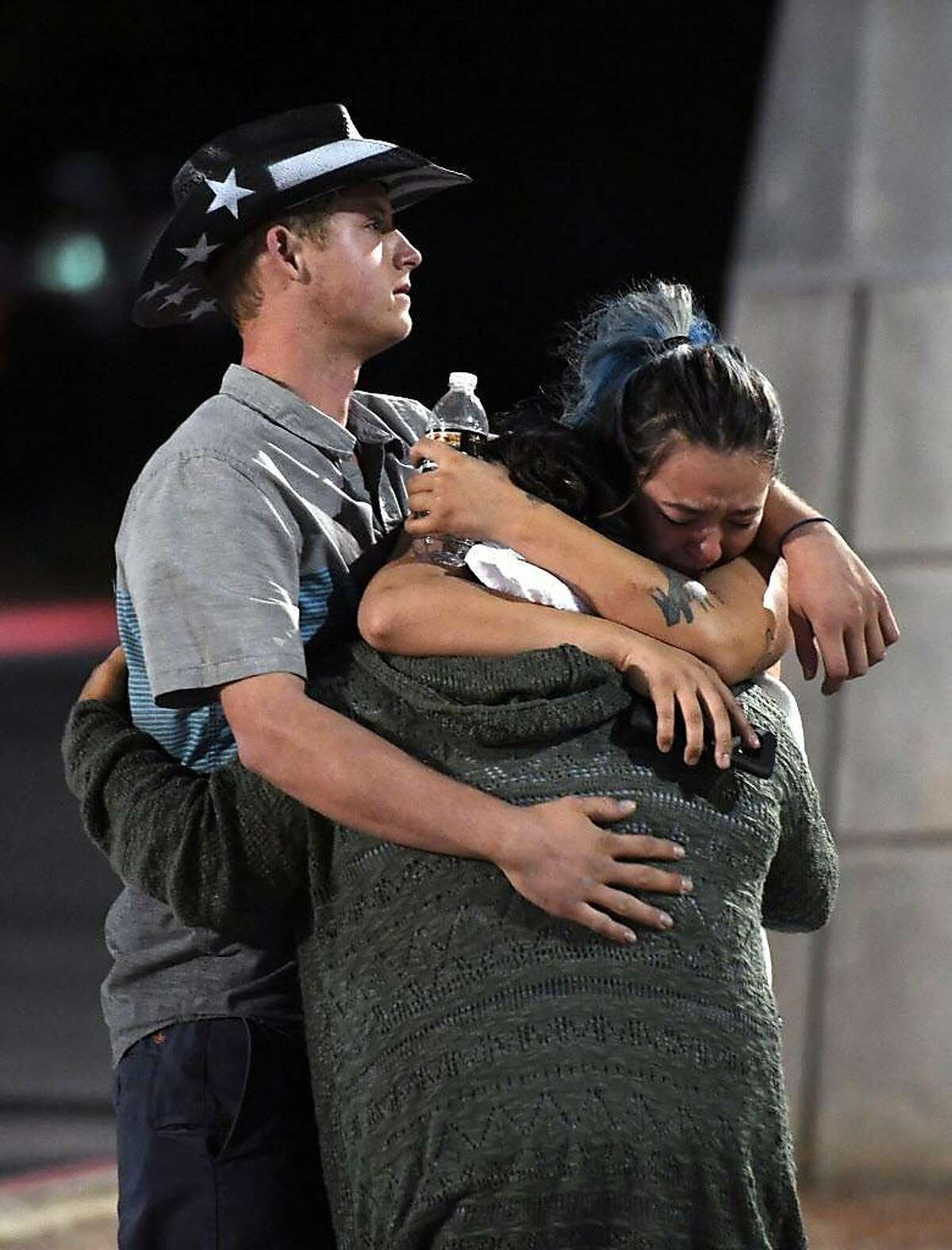 People hug and cry outside the Thomas & Mack Center after a mass shooting at the Route 91 Harvest country music festival on October 2, 2017 in Las Vegas, Nevada. A gunman, identified as Stephen Paddock, 64, of Mesquite, Nevada, opened fire from the Mandalay Bay Resort and Casino on the music festival, leaving at least 50 people dead and hundreds injured.