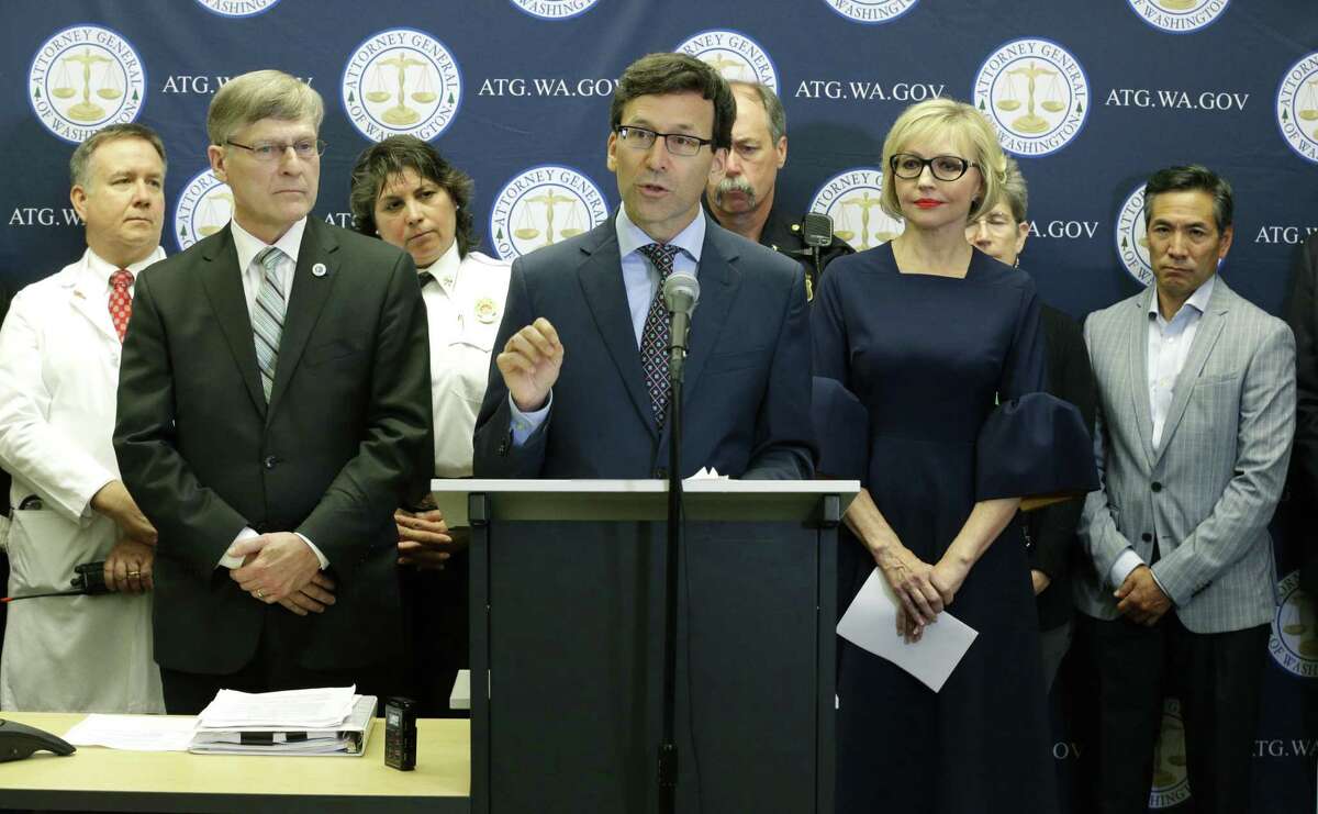 Washington Attorney General Bob Ferguson, center, talks to reporters Thursday in Seattle, as Seattle City Attorney Pete Holmes, second from left, looks on. Ferguson said Thursday that the state and the city of Seattle are filing lawsuits against several makers of opioids, including Purdue Pharma, seeking to recoup costs incurred by government when the drugs — which many officials blame for a national addiction crisis — are abused.