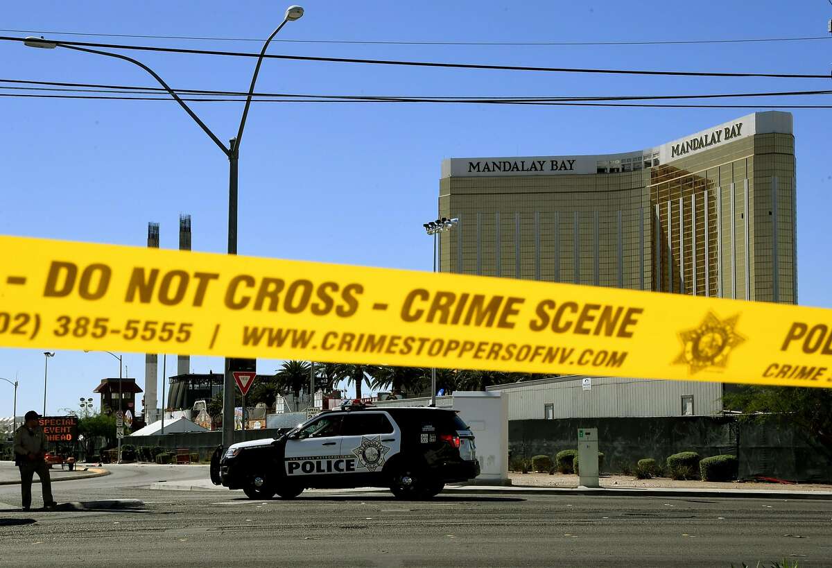 Crime scene tape surrounds the Mandalay Hotel (background with shooters window damage top right) after a gunman killed at least 58 people and wounded more than 500 others when he opened fire on a country music concert in Las Vegas, Nevada on October 2, 2017. Police said the gunman, a 64-year-old local resident named as Stephen Paddock, had been killed after a SWAT team responded to reports of multiple gunfire from the 32nd floor of the Mandalay Bay, a hotel-casino next to the concert venue. / AFP PHOTO / Mark RALSTONMARK RALSTON/AFP/Getty Images