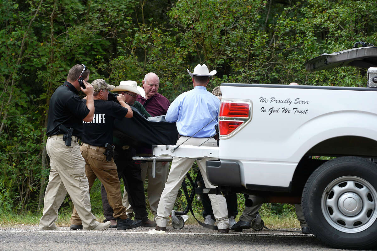 Investigators move the body of a 19-year-old man along Texas 1135 in Orange County on Monday. The man is believed to be "a person of interest" in the death of a Silsbee teen. Photo taken Monday 10/2/17 Ryan Pelham/The Enterprise