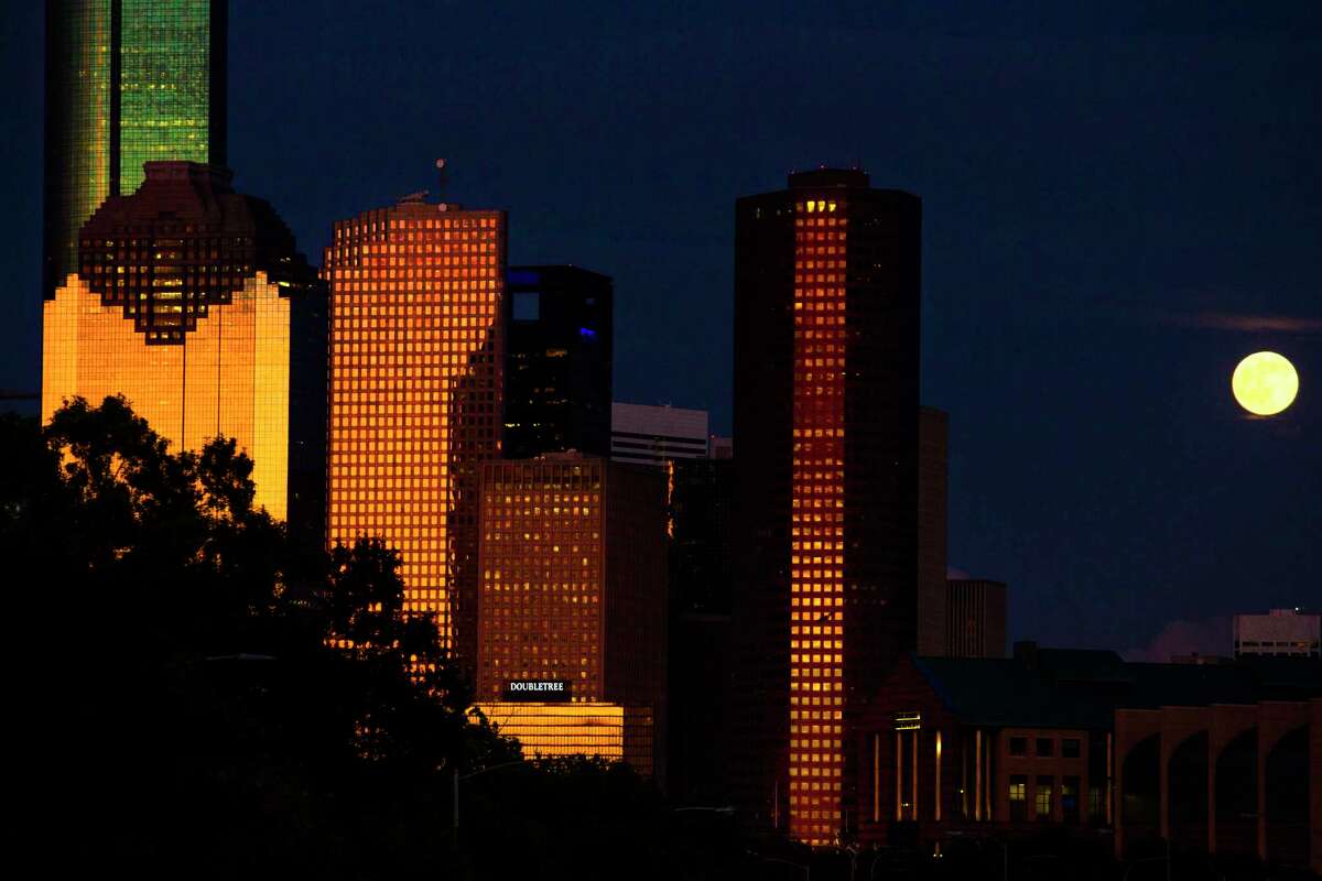 The full moon rises behind the Houston skyline as the sun sets July 19, 2016. ( Michael Ciaglo / Houston Chronicle )