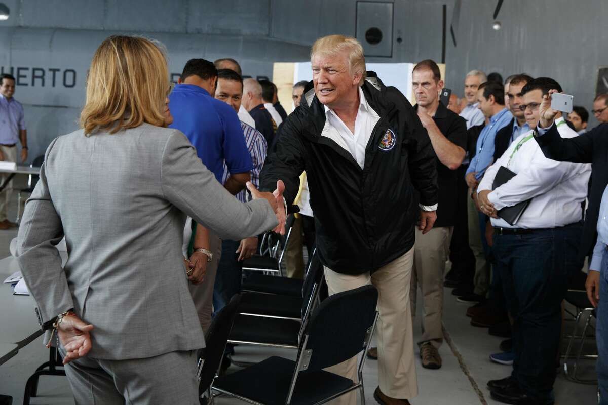 President Donald Trump shakes hands with San Juan Mayor Carmen Yulin Cruz during a briefing on hurricane recovery efforts with first responders at Luis Muniz Air National Guard Base, Tuesday, Oct. 3, 2017, in San Juan, Puerto Rico. (AP Photo/Evan Vucci)