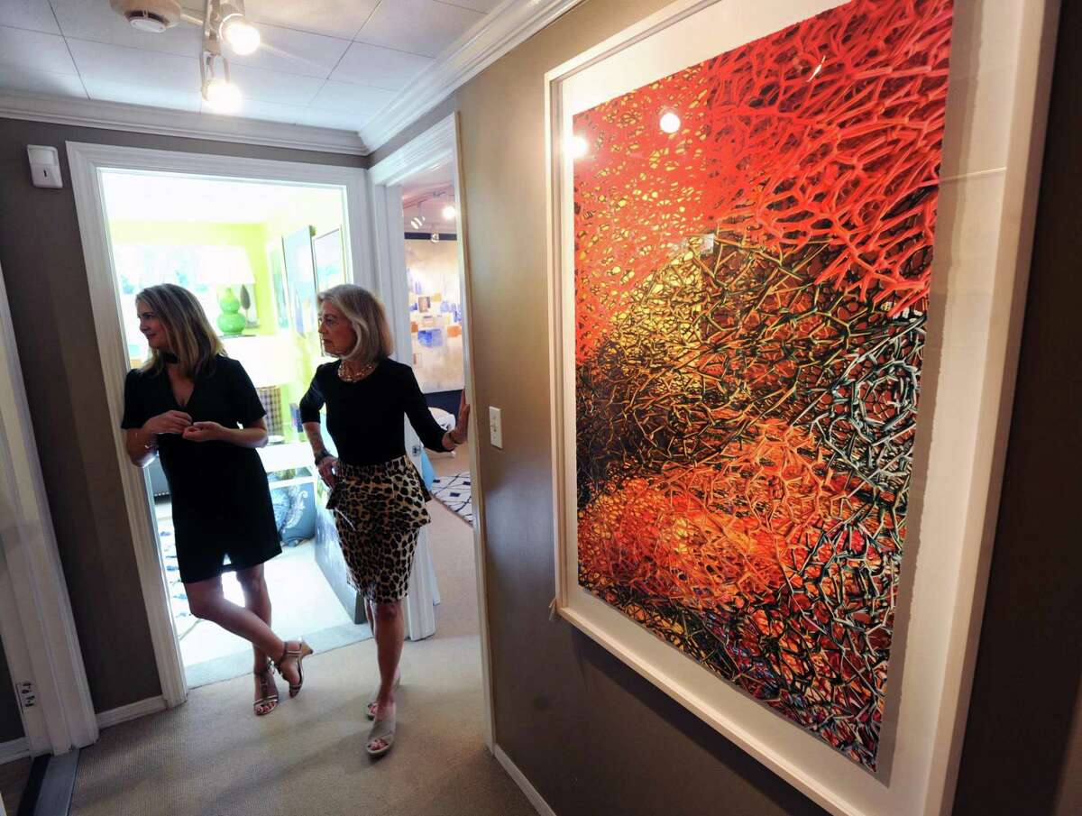 Camilla Cook, left, and Sandra Morgan stand near a work by artist and photographer Janice Mehlman of Brooklyn, N.Y., titled "Inappropriate Entanglements," that is part of the "Punch & Sizzle" art show featuring five artists at the SM Home Art Gallery in Greenwich, Conn., Thursday, Sept. 28, 2017. Morgan is the owner of the gallery and Cook is an associate art director there. The shows runs until November 18, 2017 at the gallery located at 70 Arch Street in Greenwich.