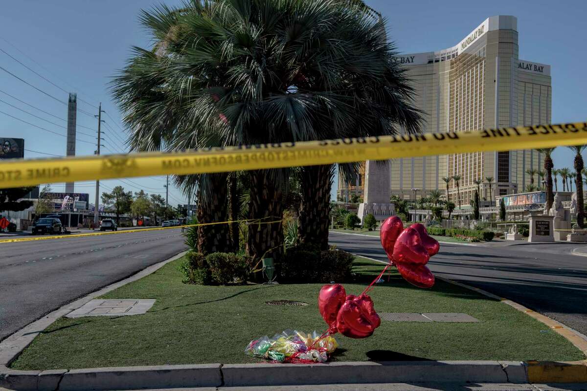 Flowers, balloons and police tape at the intersection of Las Vegas Boulevard and Reno Avenue near the Mandalay Bay Resort and Casino, from where a lone gunman's barrage left at least 59 dead and 527 injured, in Las Vegas. (Hilary Swift/The New York Times)