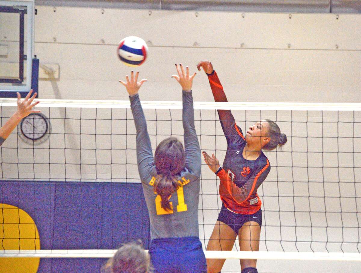 Edwardsville freshman Alexa Harris, right, goes up for a kill during the first game of Tuesday’s Southwestern Conference match at O’Fallon.