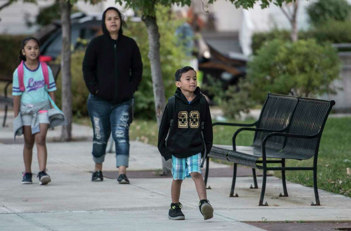 Margie Maipi walks with Lewin Ifenuk, 7, foreground and U-Me Ifenuk, 8, on their way to Pine Hills Elementary School on National Walk to School Day Wednesday Oct. 4, 2017 in Albany, N.Y. (Skip Dickstein/Times Union)