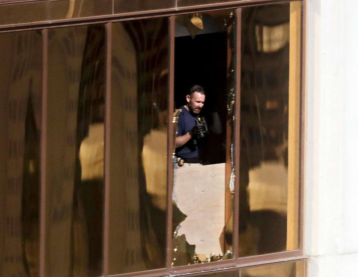 An investigator works in the room at the Mandalay Bay Resort and Casino where a gunman opened fire from on a music festival Wednesday, Oct. 4, 2017, in Las Vegas. The gunman killed dozens and injuring hundreds at the festival. (AP Photo/Gregory Bull)
