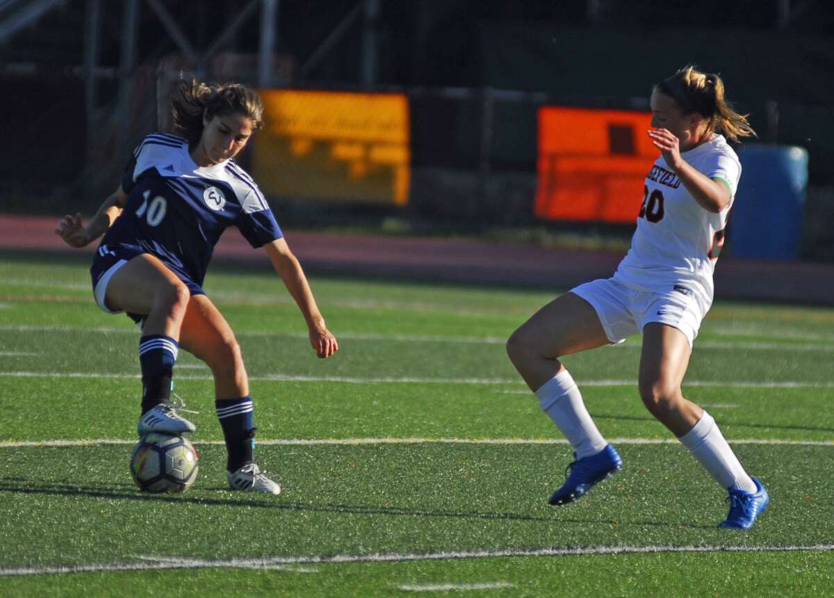 Wilton’s Zoe Lash, left, dribbles while Ridgefield’s Megan Klosowski defends during a game on Wednesday.
