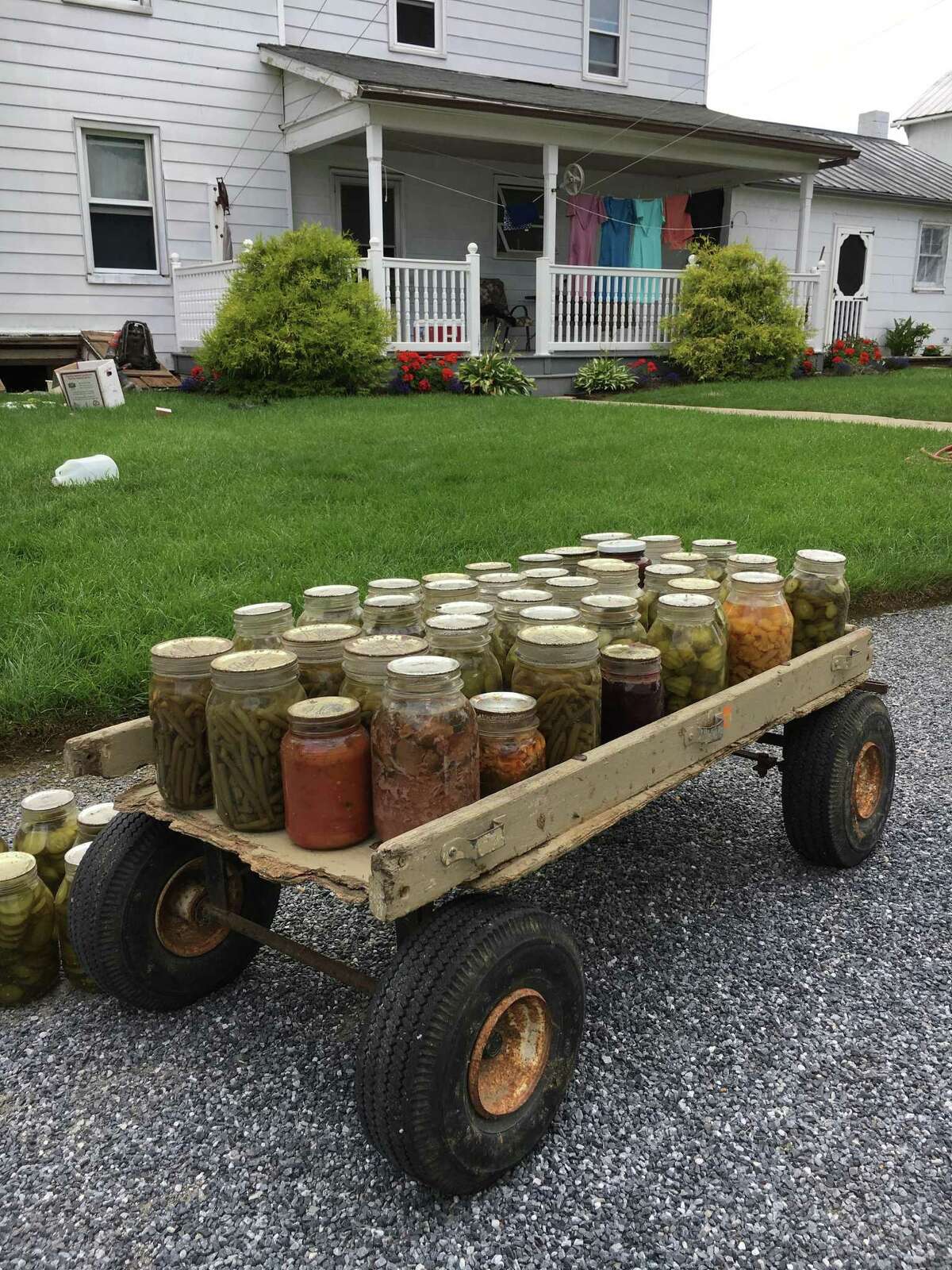 A wagon full of homemade jams and pickles is ready to sell at the farmer's market or farm stand.