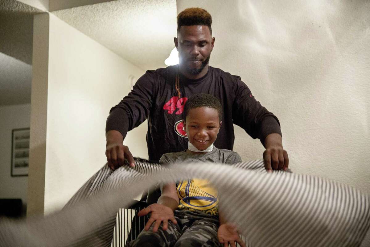 Jamahl Mackey Sr. preps his son Jamahl Jr. for a haircut at their home on Thursday, September 28, 2017 in Sacramento. The two were formerly homeless and slept in a car in in San Francisco but now receive support from Hamilton Families, San Francisco’s leading service provider for the homeless, and other San Francisco city agencies. With the support of these agencies, Jamahl Sr. is enrolled in barber school.