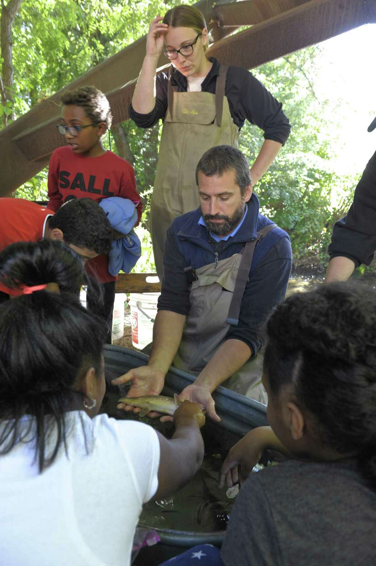 Brian Eltz and Mallory Humphrey, from the DEEP Fish Division, show Pembroke School students fish taken from the Still River during the Housatonic Valley Association (HVA) Still River Day. The event is used to teach Danbury middle and elementary school students about the environment in an outdoor classroom setting next to the Still River. Wednesday, October 4, 2017, in Danbury, Conn.