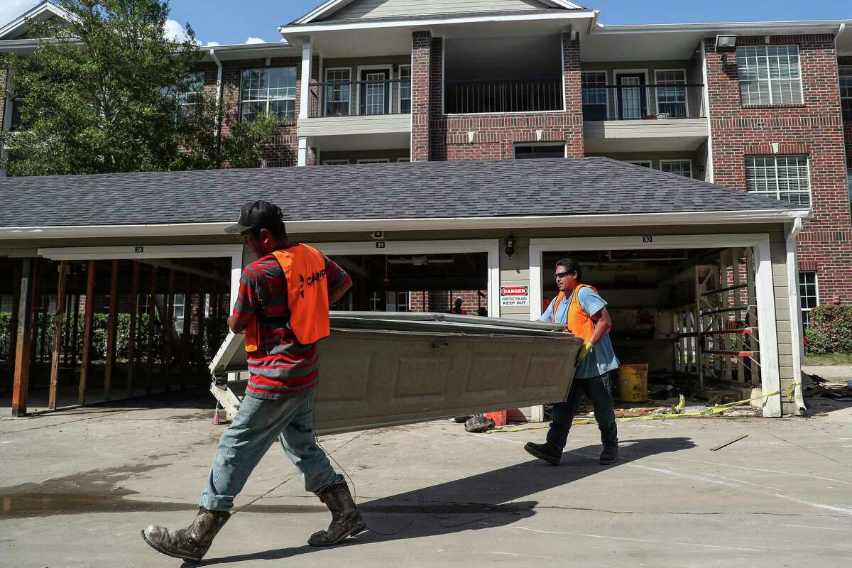 CAMP Construction Services contractors remove the door from a garage at apartment that flooded during Hurricane Harvey. ﻿