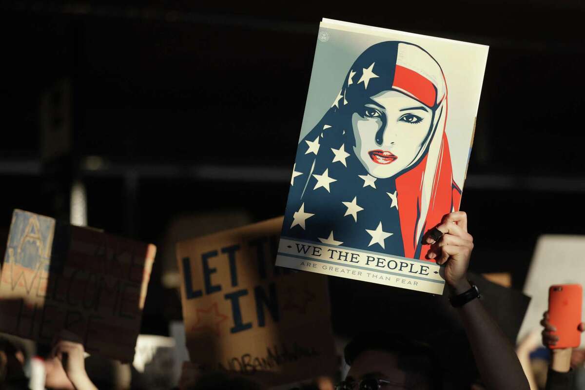 In January, A protester holds a sign at San Francisco International Airport during a demonstration to denounce President Donald Trump’s executive order that bars citizens of seven predominantly Muslim-majority countries from entering the U.S. A new ban replaces that and it is as discriminatory as the first.