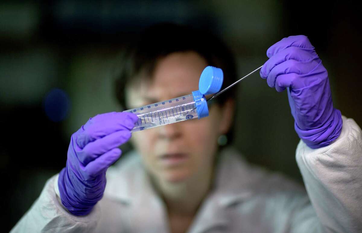 This photo taken Nov. 25, 2013 shows microbiologist Dr. Molly Freeman pulling Listeria bacteria from a tube to be tested for its DNA fingerprinting in a foodborne disease outbreak lab at the federal Centers for Disease Control and Prevention in Atlanta. (AP Photo/David Goldman) ORG XMIT: MER2014040607425848