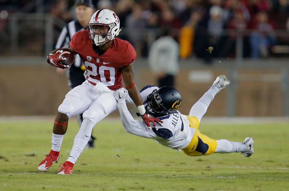 Stanford's Bryce Love, 20 picks up a first quarter first dfown as he is chased by California's Darius Allensworth, 2 as Stanford takes on California in the 118th Big Game at Stanford Stadium, on Sat. November 21, 2015, in Stanford, Calif.