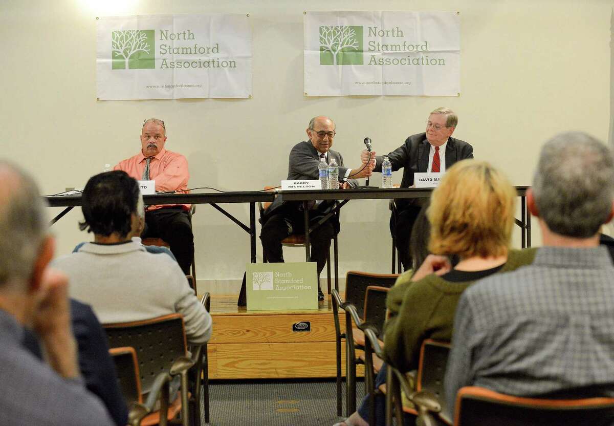 Unaffiliated candidate John Zito, at left, sits quietly as Republican challenger Barry Michelson hands over the microphone to Democratic incumbent David Martin during a forum for the three mayoral candidates at the Harry Bennett Library in Stamford, Connecticut on Wednesday, Oct. 4, 2017. The event held by the North Stamford Association, allowed each candidate to answer questions from the residents attending the event.