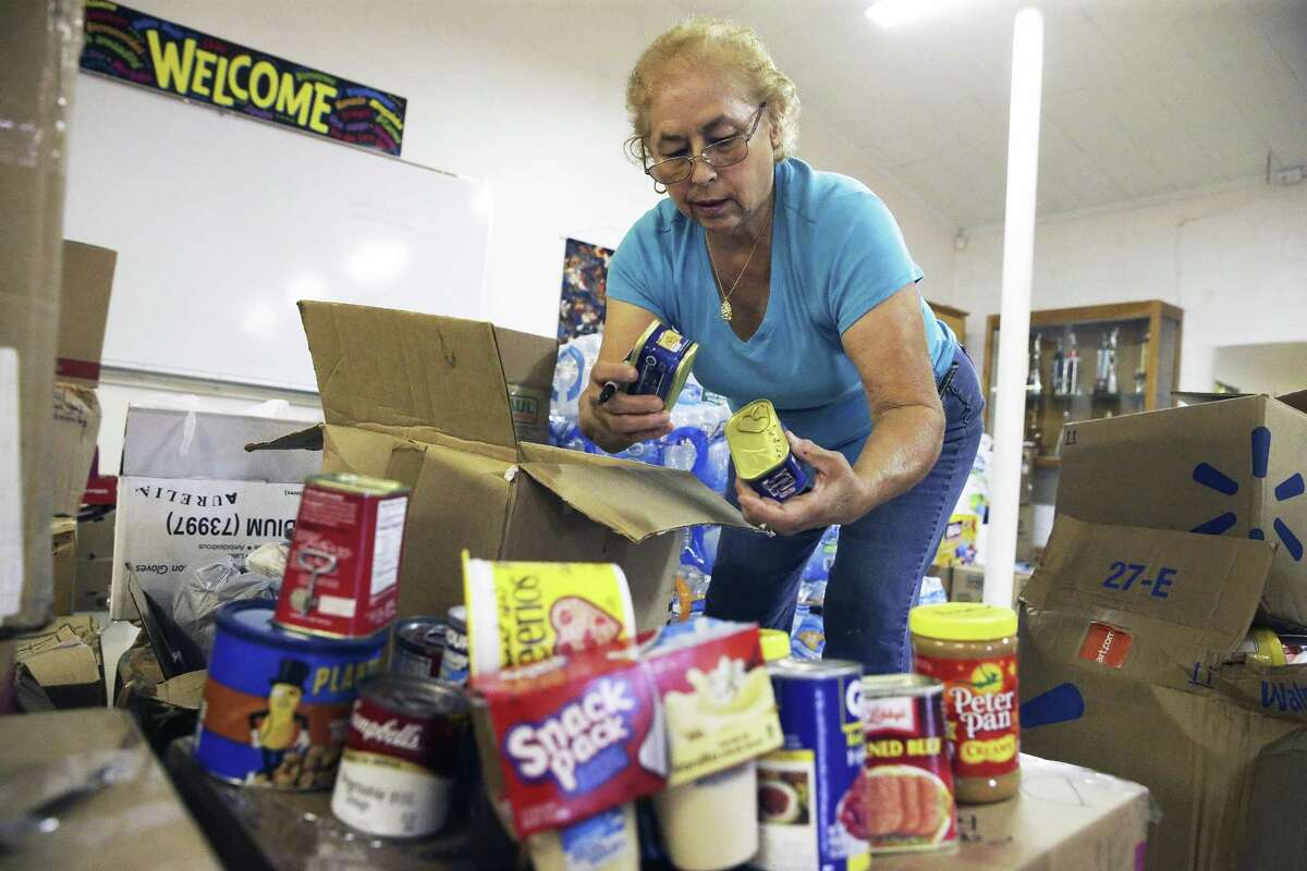 Irma Decker marks out scan codes as she packs boxes with canned ggods while parishioners at the Gethsemane Lutheran Church pack boxes of relief supplies on October 5, 2017 to be sent to Puerto Rico with church members who will be making a trip soon.