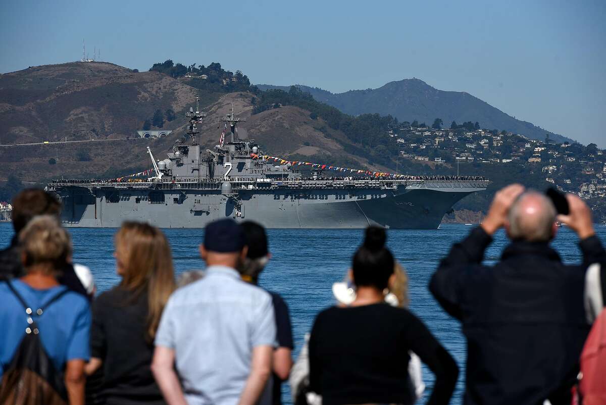 People watch as the USS Essex passes by during a Fleet Week celebration at Marina Green in San Francisco, Calif., on Friday, October, 6, 2017.