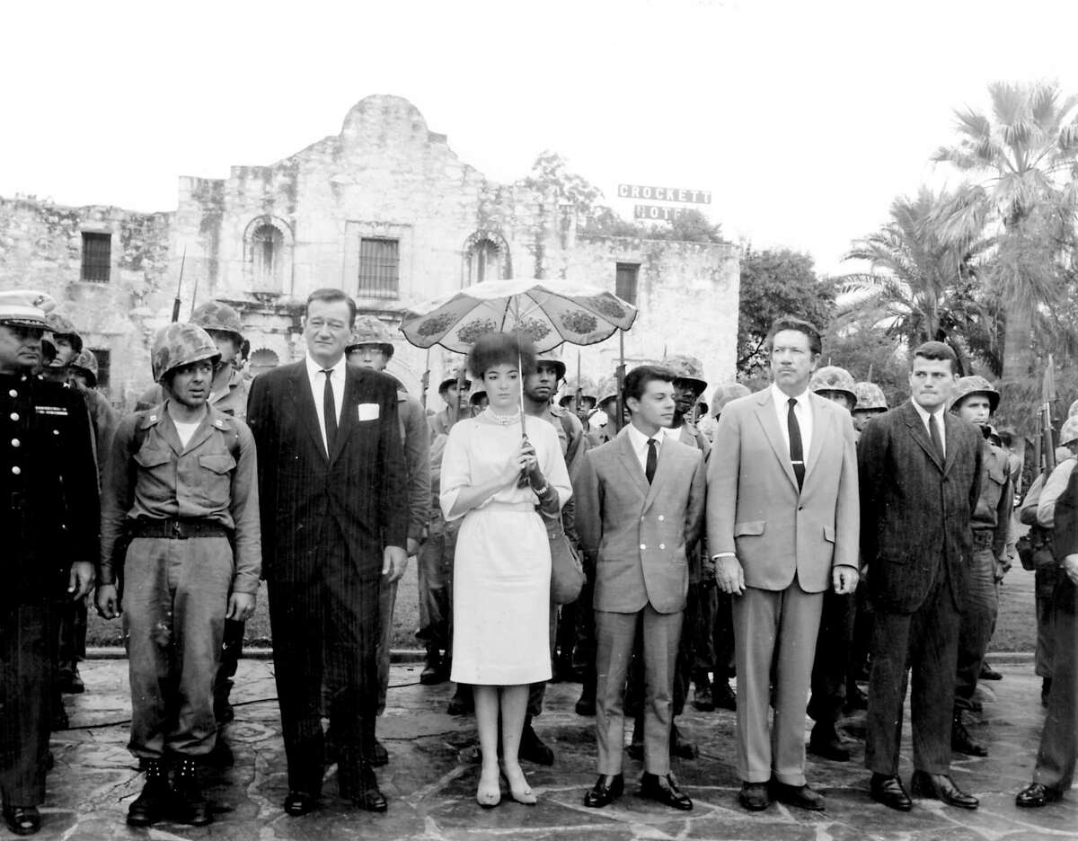 Cast members of the 1960 film "The Alamo," including (from left of the helmeted soldier) John Wayne, Linda Cristal, Frankie Avalon, Richard Boone and Pat Wayne, pay tribute to the fallen defenders of the Alamo during a ceremony on Alamo Plaza on Oct. 24, 1960, the morning of the world premiere of the film.
