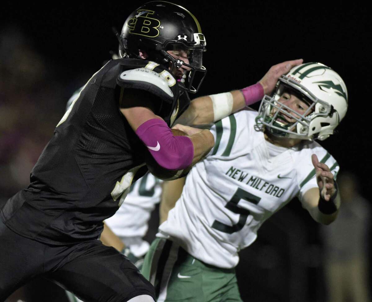 Barlow’s Trevor Furrer (18) tries to push his way past New Milford’s Austin Swanson Friday night.