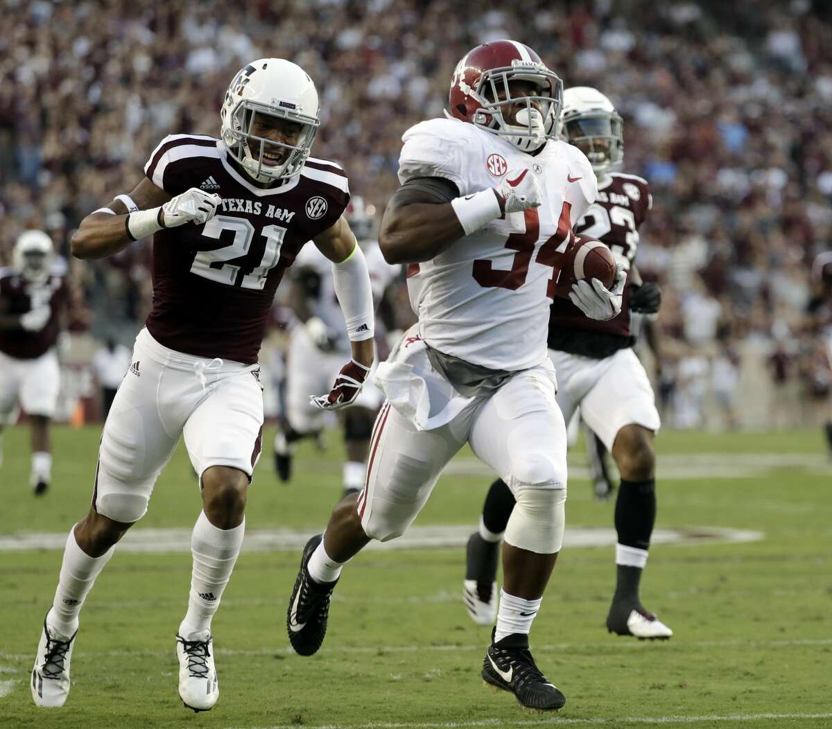 Alabama running back Damien Harris (34) runs for a 75-yard touchdown as Texas A&M's Charles Oliver (21) and Armani Watts (23) pursue during the first quarter of an NCAA college football game Saturday, Oct. 7, 2017, in College Station, Texas. (AP Photo/David J. Phillip)