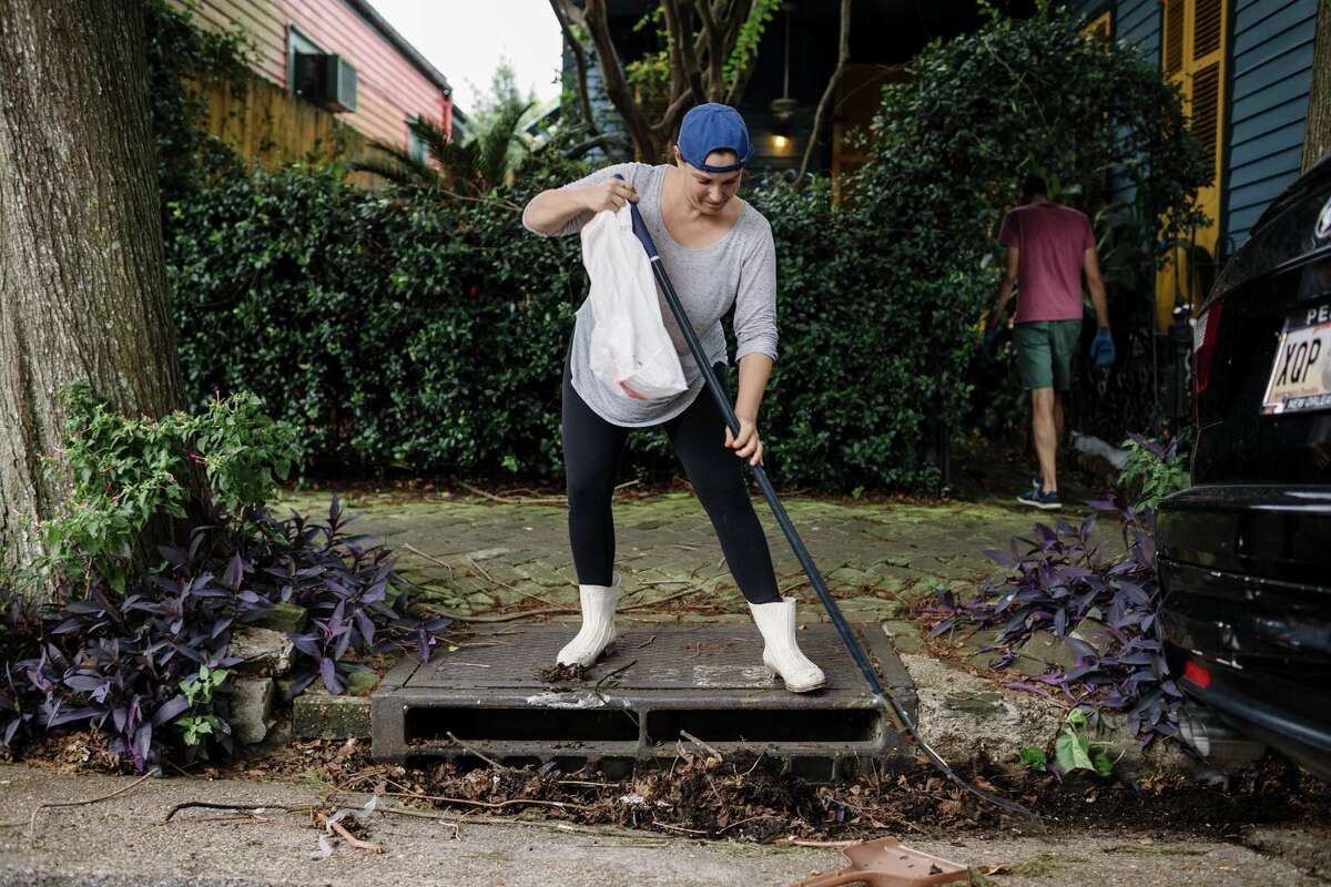 TOPSHOT - Johnice Katz works to clear the storm drain in front of her home in preparation for Hurricane Nate in New Orleans on October 07, 2017. Residents in three states along the US Gulf Coast scrambled to complete preparations Saturday ahead of Hurricane Nate as officials warned conditions would turn treacherous after sunset. Nate was forecast to arrive late Saturday as a Category Two hurricane, packing winds topping 90 miles per hour as it churned in the Gulf of Mexico. The storm killed at least 28 people in Central America. / AFP PHOTO / Bryan Tarnowski (Photo credit should read BRYAN TARNOWSKI/AFP/Getty Images)