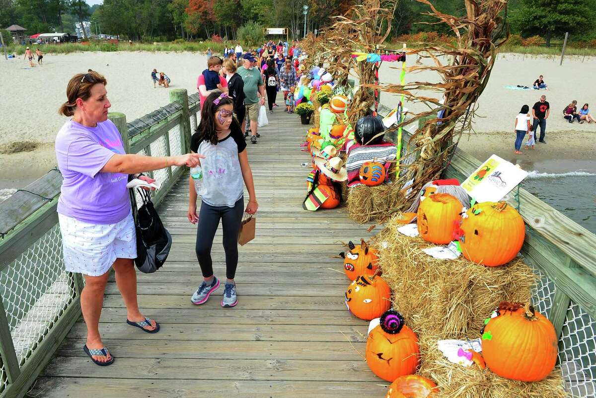 Lisa Curtin, of Milford, and her niece Caitlin, 9, check out one of the displays during the Pumpkins on the Pier Festival at Walnut Beach in Milford, Conn., on Saturday Oct. 7, 2017. The festival included a pumpkin patch with over 3000 pumpkins, games and rides for the kids, pumpkin carving and decorating, food trucks, craft vendors, and of course the beautifully decorated pier.