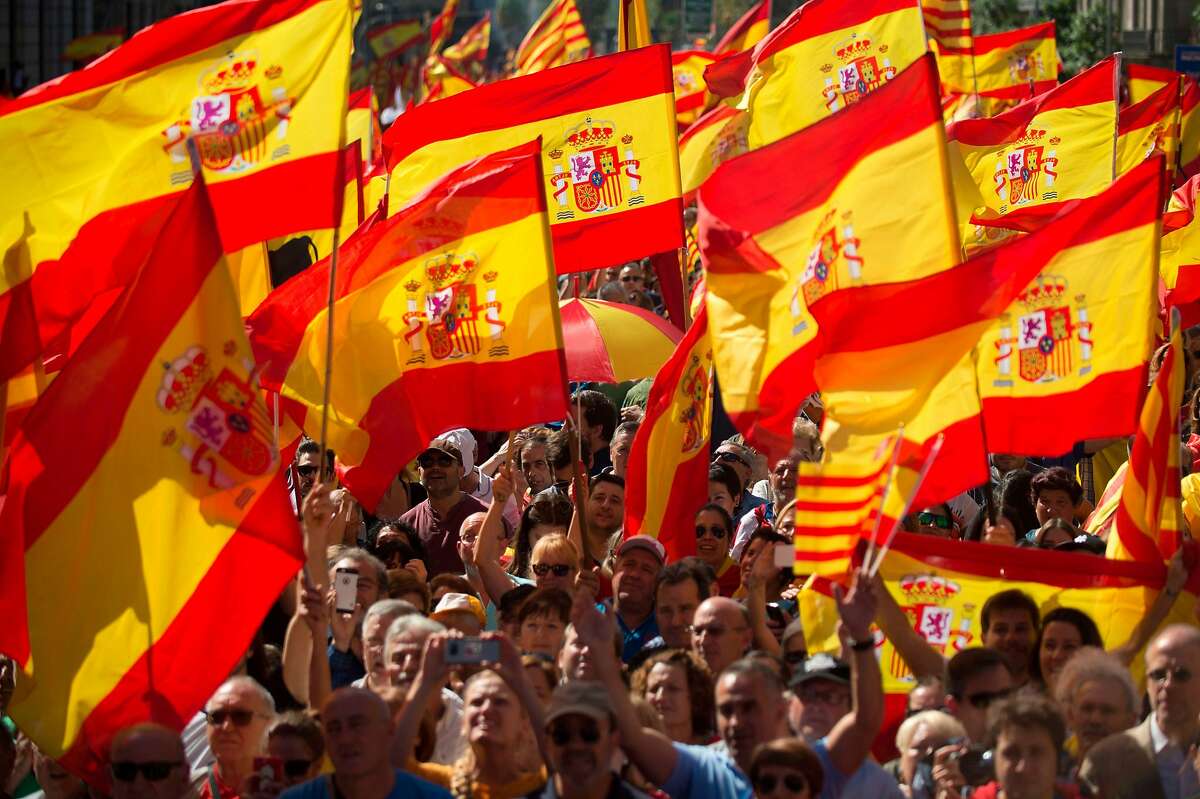 Protesters hols Spanish flags during a demonstration called by "Societat Civil Catalana" (Catalan Civil Society) to support the unity of Spain on October 8, 2017 in Barcelona. Ten of thousands of flag-waving demonstrators packed central Barcelona to rally against plans by separatist leaders to declare Catalonia independent following a banned secession referendum. Catalans calling themselves a "silent majority" opposed to leaving Spain broke their silence after a week of mounting anxiety over the country's worst political crisis in a generation. / AFP PHOTO / JORGE GUERREROJORGE GUERRERO/AFP/Getty Images