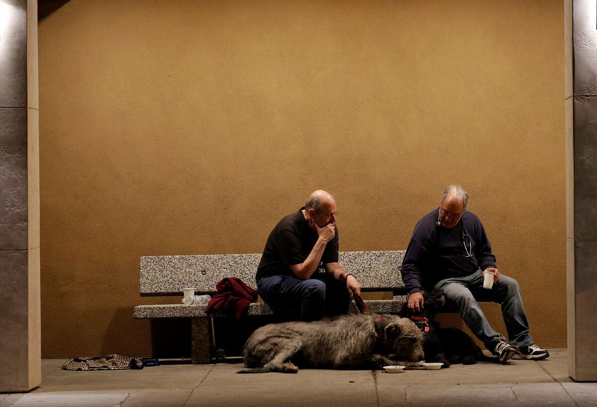Peter Gennet sits with Dr. Larry Posner with Peter's dogs Quinn, and Rufus at Crosswalk Church after they were both evacuated from their homes in Napa, Calif., on Monday, October 9, 2017. Several large wildfires consumed several structures and threatened hundreds of others in Napa and Sonoma Counties.