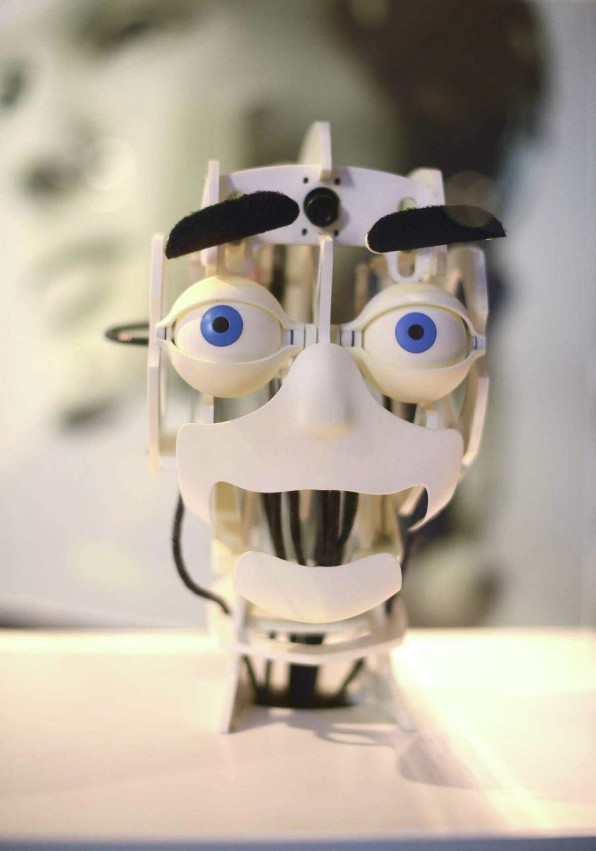 A robotic head smiles as it mimics a viewer at the at the "Hey, That Robot’s Copying Me" display at the Science Fiction, Science Future exhibit at the DoSeum on Saturday, Oct. 7, 2017. The exhibit includes displays that show 3D holograms, teleportation, cyborg design, and artificial intelligence. The exhibit will be on display until Jan. 6, 2018.