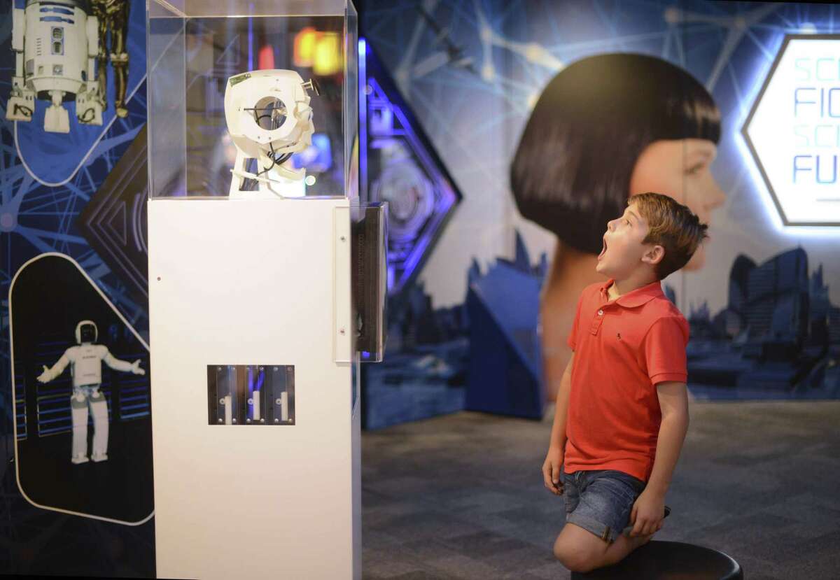 Garrett Rivera attempts to get a robotic head to mimic his facial expressions at the Science Fiction, Science Future exhibit at the DoSeum on Saturday, Oct. 7, 2017. The exhibit includes displays that show 3D holograms, teleportation, cyborg design, and artificial intelligence. The exhibit will be on display until Jan. 6, 2018.