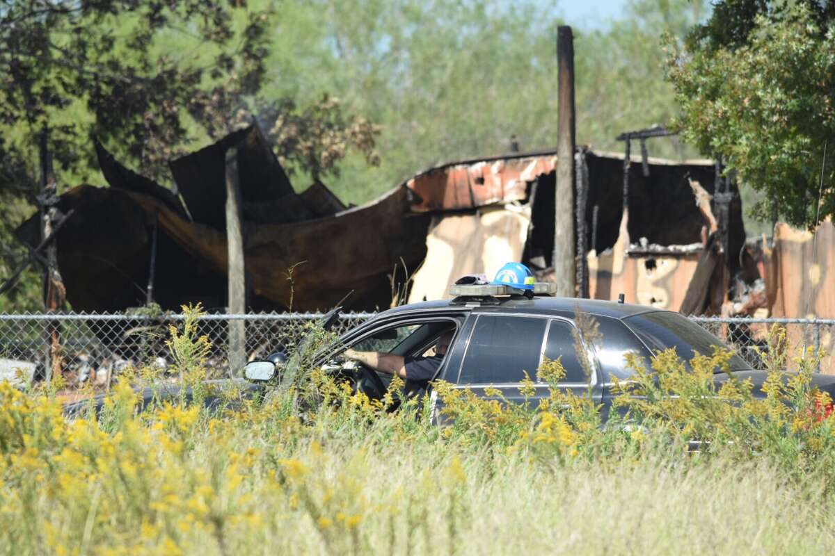 Arson investigators and firefighters comb over the remains of a mobile home in Seguin, Texas, that authorities believe was intentionally set ablaze in a murder-suicide.