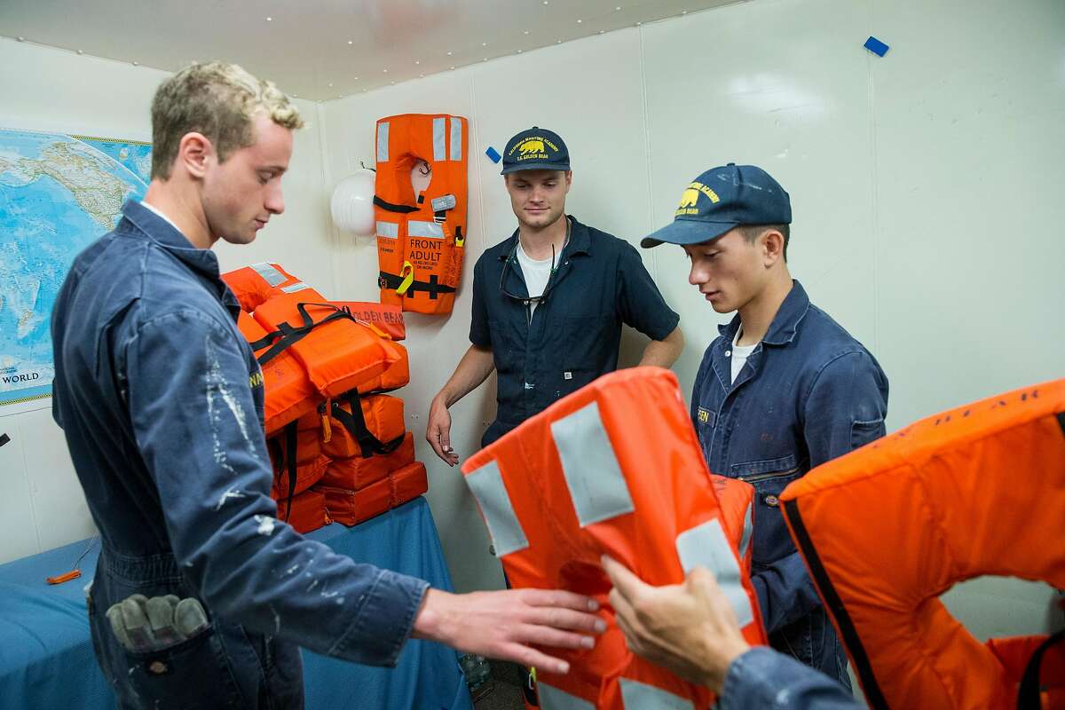 Goody Walowit, Colby White and Joseph Jepsen (left to right) arrange life jackets while preparing the training ship Golden Bear for homecoming weekend visitors at the California State University Maritime Academy in Vallejo, Calif., on Monday, October 2, 2017. The university is the only degree-granting maritime university in the West.