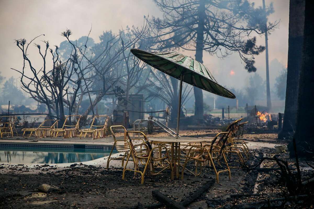 Chairs and an umbrella are seen charred and melted beside the pool at Journey's End mobile home after the Tubbs fire tore through the property on Mendocino Avenue in Santa Rosa, Calif., on Monday, Oct. 9, 2017.