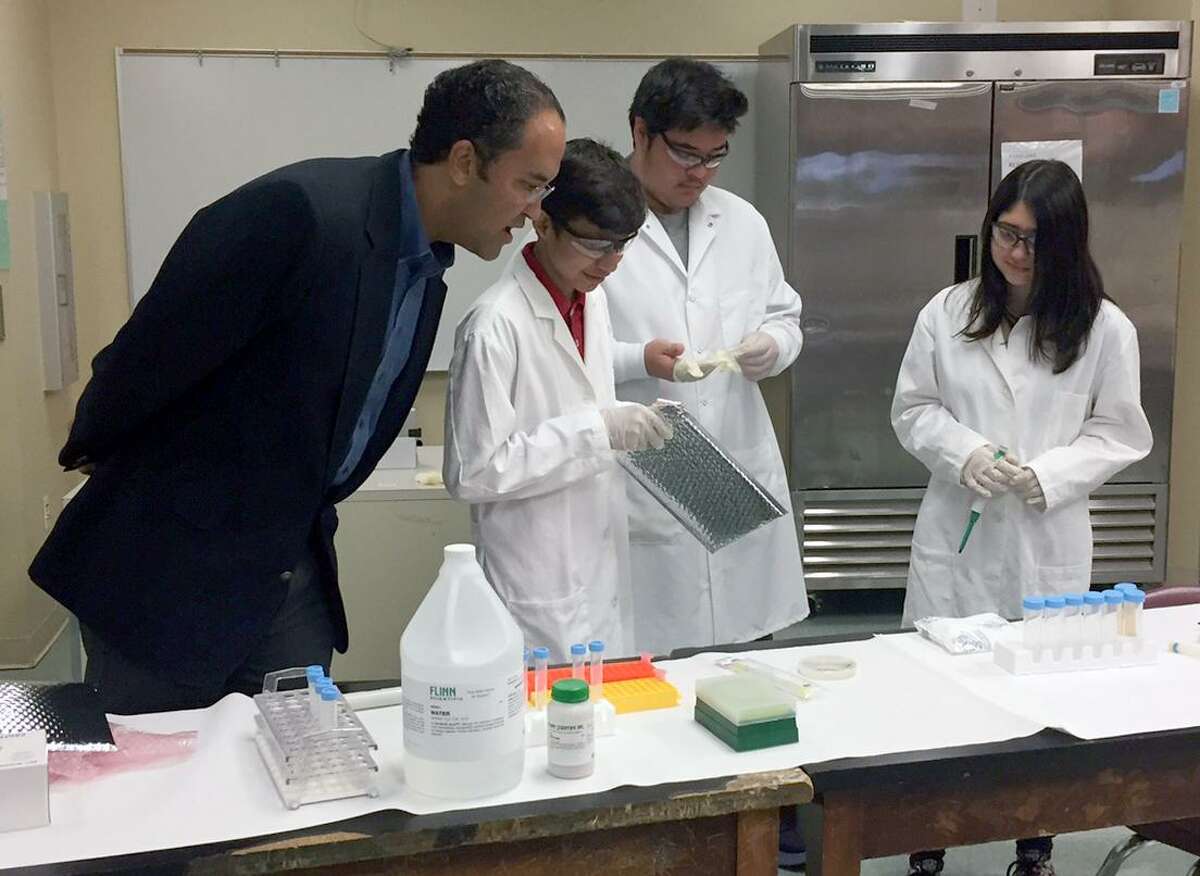 U.S. Rep. Will Hurd, from left, watches Southside High School 9th grade students Carlos Gonzalez, Neco Jimenez and Lydia Araujo as they open the returned experiment they sent to the International Space Station.