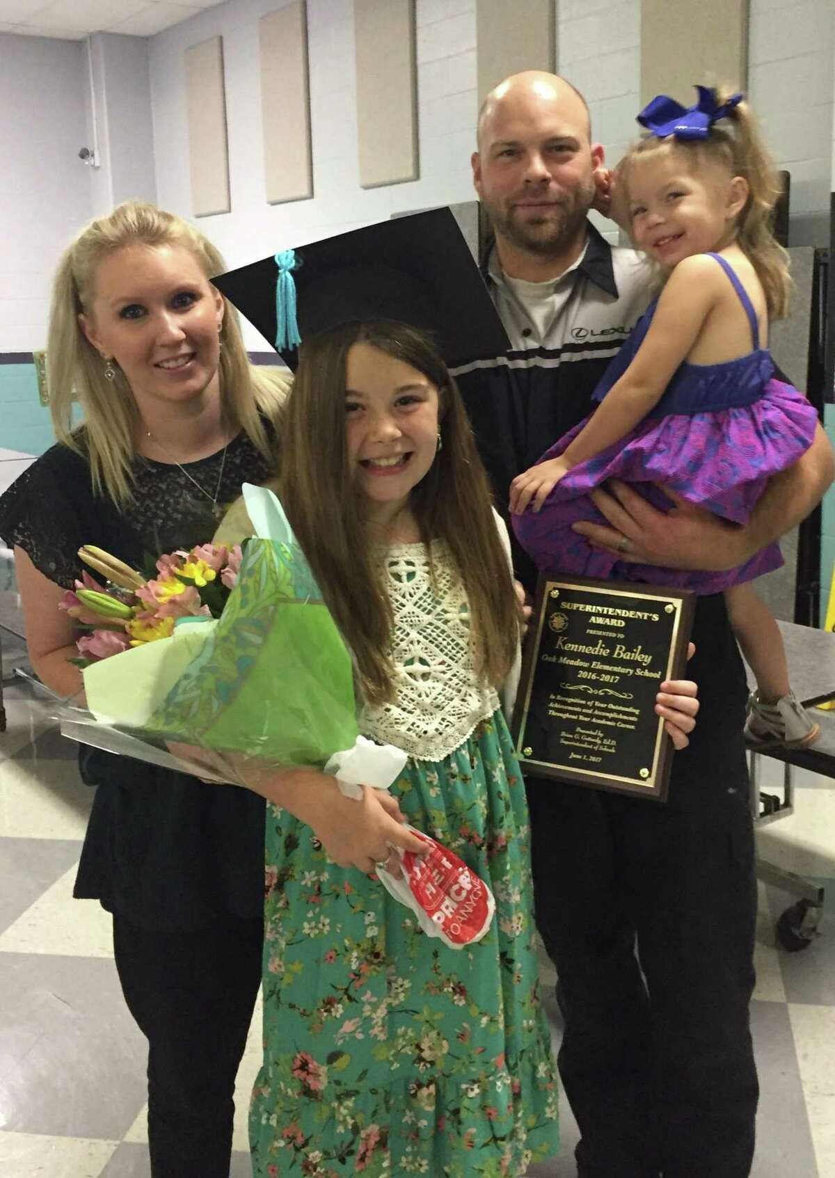 Kennedie Bailey poses with her mother, Lindsey Bendele, her stepfather, Chris Bendele, and her sister, Presley, 4, before starting chemotherapy over the summer. Kennedie was diagnosed with rhabdomyosarcoma, a form of cancer that develops from connective tissues in the body including, muscles, bones, joints and fat.