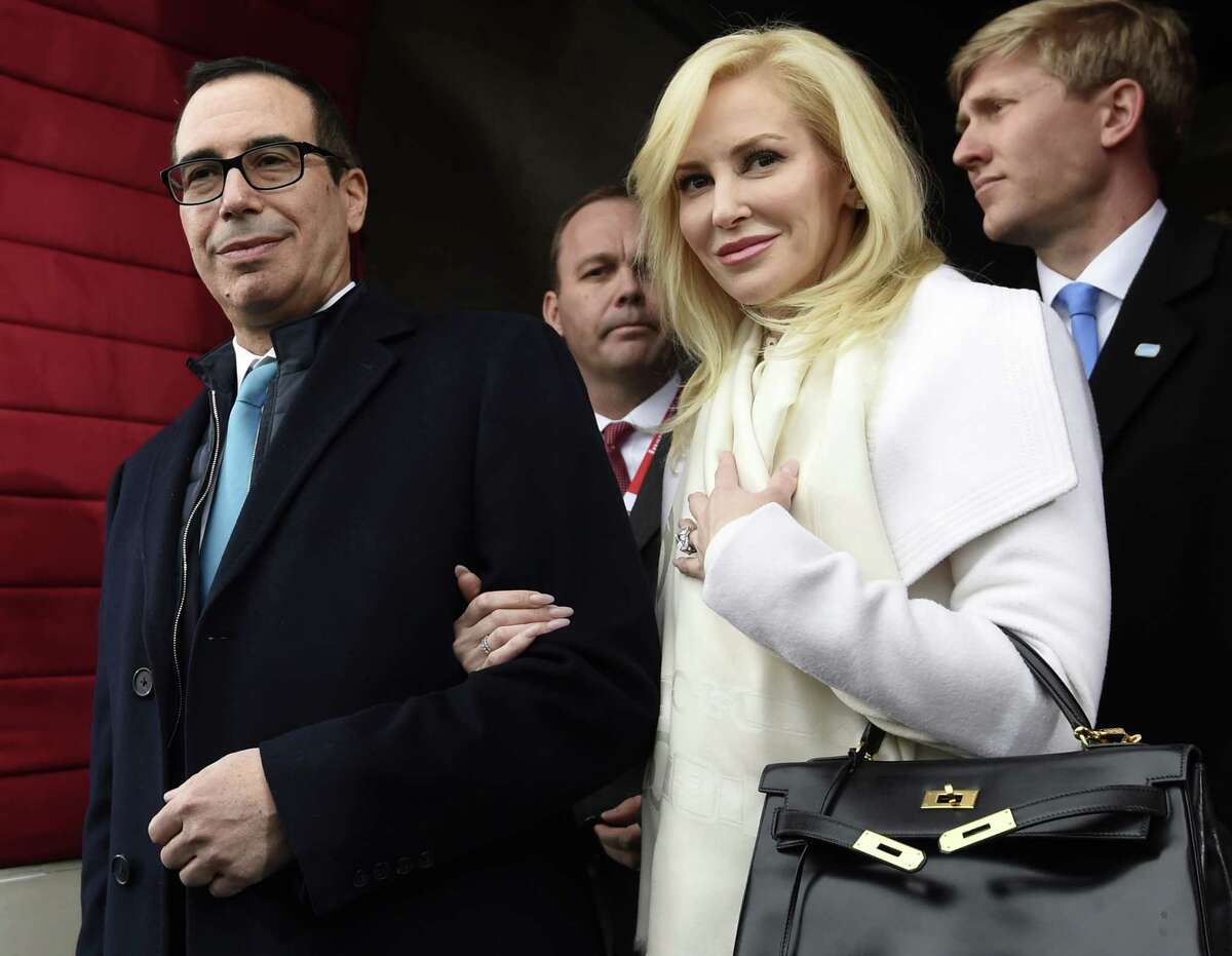 FILE - In this Friday, Jan. 20, 2017, file photo, then Treasury Secretary-designate Stephen Mnuchin and his then-fiancee, Louise Linton, arrive on Capitol Hill in Washington, for the presidential inauguration of Donald Trump. Linton responded to a social media critic on Aug. 21, 2017, telling the mother of three that that she was Â?“adorably out of touch.Â?” Mnuchin and Linton were married in June. (Saul Loeb/Pool Photo via AP, File)