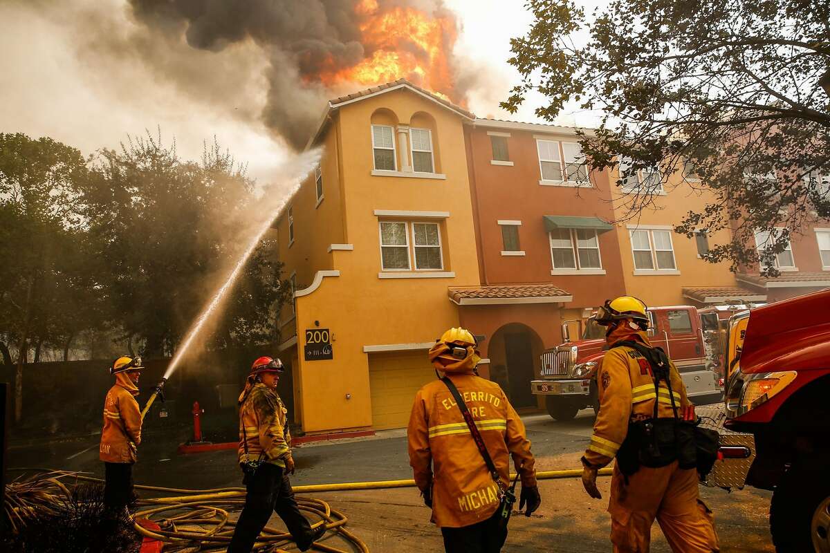 Firefighters work to contain the Tubbs fire at the Overlook apartment complex off of Bicentennial Way in Santa Rosa, Calif., on Monday, Oct. 9, 2017.