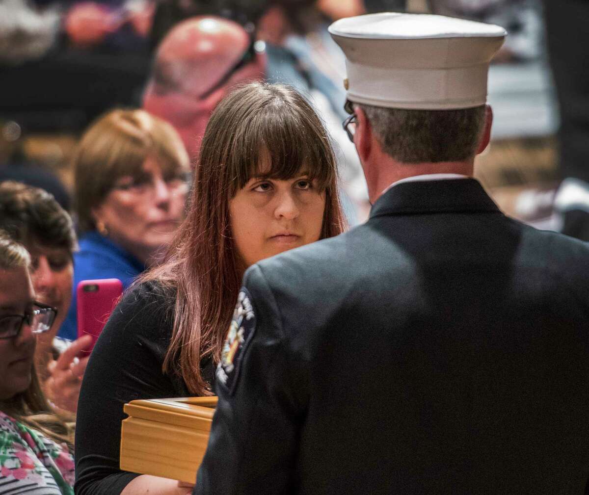 Andria Capobianco accepts a New York State Flag from William R. Davis Jr., deputy state fire administrator on behalf of her deceased father NYFD firefighter Carl Capobianco during the 20th Annual New York State Fallen Firefighters Memorial ceremony at the Convention Center at the Empire State Plaza on Tuesday, Oct. 10, 2017, in Albany, N.Y. (Skip Dickstein/Times Union)