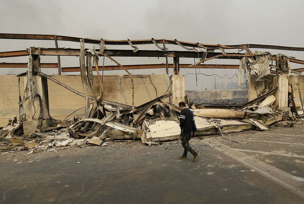 A man walks past the front of a Kmart store destroyed by a fire in Santa Rosa.