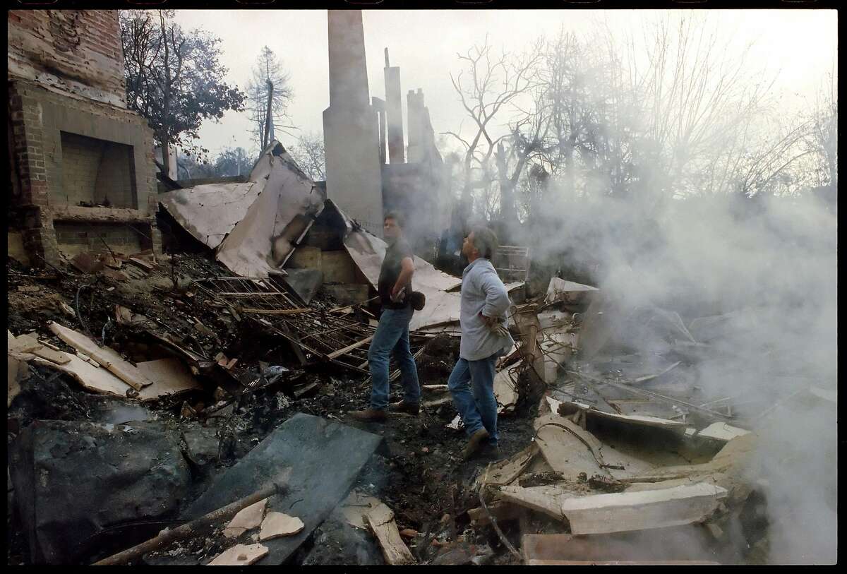 Two men inspect a destroyed house on Alvarado Rd., October 21, 1991, the morning after the Oakland Hills fire tore through the area.