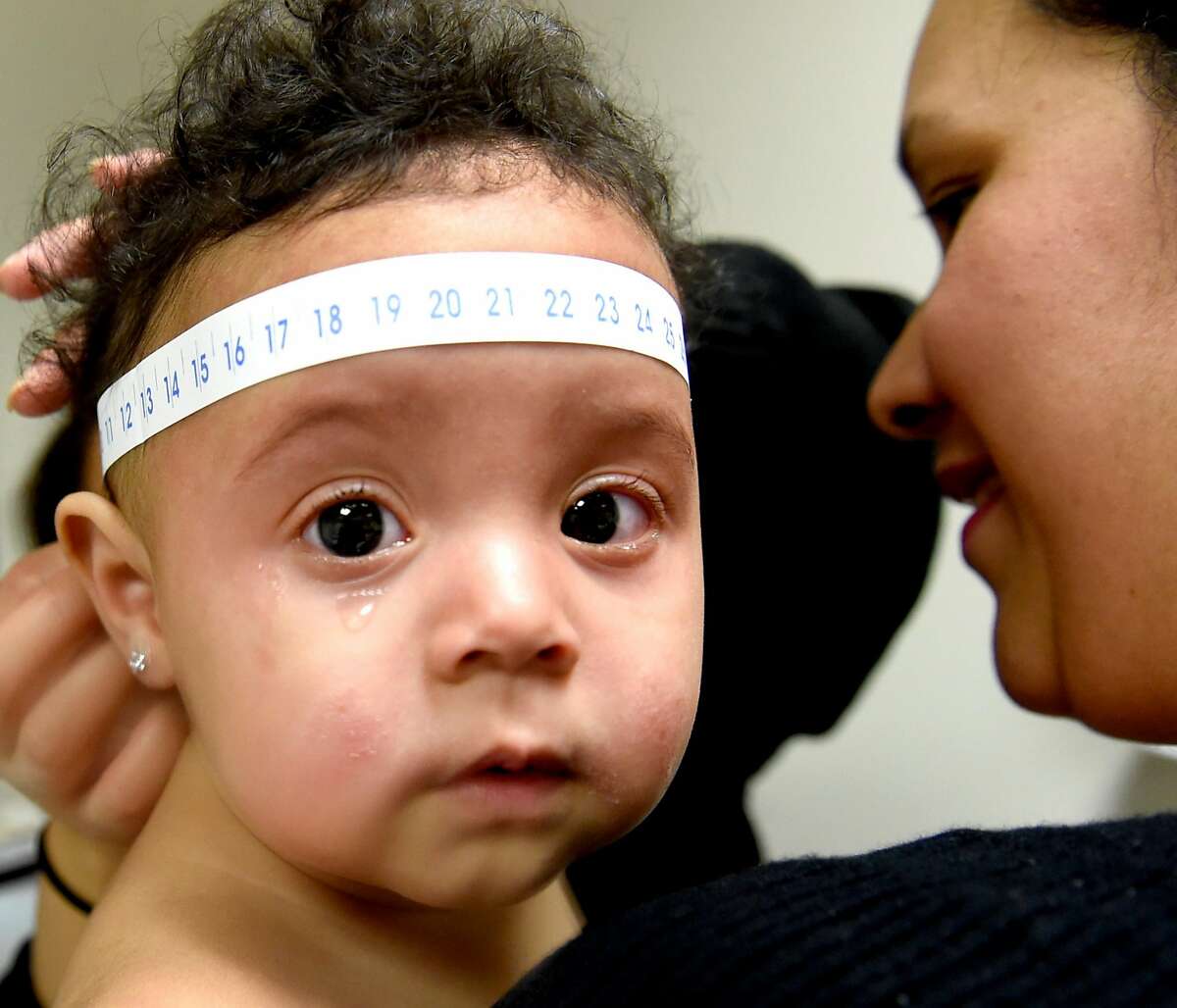 New Haven, Connecticut - Tuesday, October 3, 2017: Registered Nurse Cinthya (Cq) Chumpitaz of the Yale Children's Hispanic Clinic measures the head of Angela Guzman, 1, of New Haven as mother Elena Martinez holds her son during the one-year vitals check up of the baby at the clinic recently. This clinic, also known as Y-CHiC. is a culturally and linguistically based primary care service for children ages 0-12 months and their families. This new program integrates language and cultural competency into residency training while at the same time providing quality pediatric clinical care to children and their families completely in Spanish.