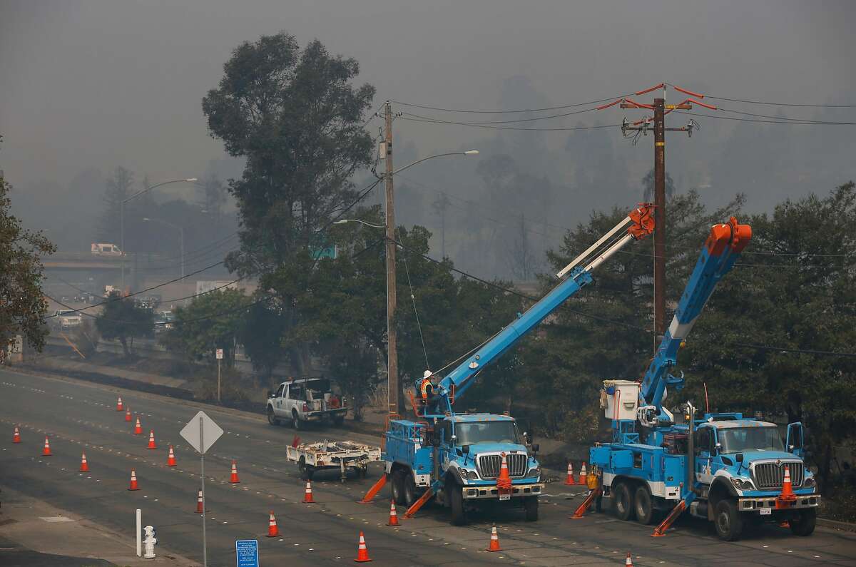 Workers from PG&E work on replacing a downed power line on Cleveland Ave. Oct. 10, 2017 in Santa Rosa, Calif.