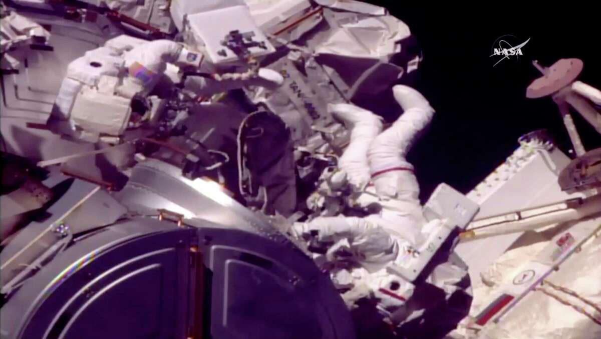 In this frame from NASA TV, Astronauts Mark Vande Hei and Randy Bresnik, right, emerge from the International Space Station on Tuesday, Oct. 10, 2017. The astronauts went out on a spacewalk to grease the robot arm's new hand. (NASA TV via AP)