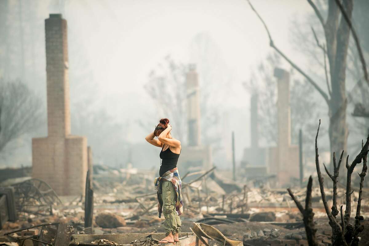 Jeanette Scroggins pauses while searching for signs of her aunt, Karen Aycock, who has been missing since the Tubbs fire roared through her Coffey Park neighborhood in Santa Rosa, Calif., on Tuesday, Oct. 10, 2017.