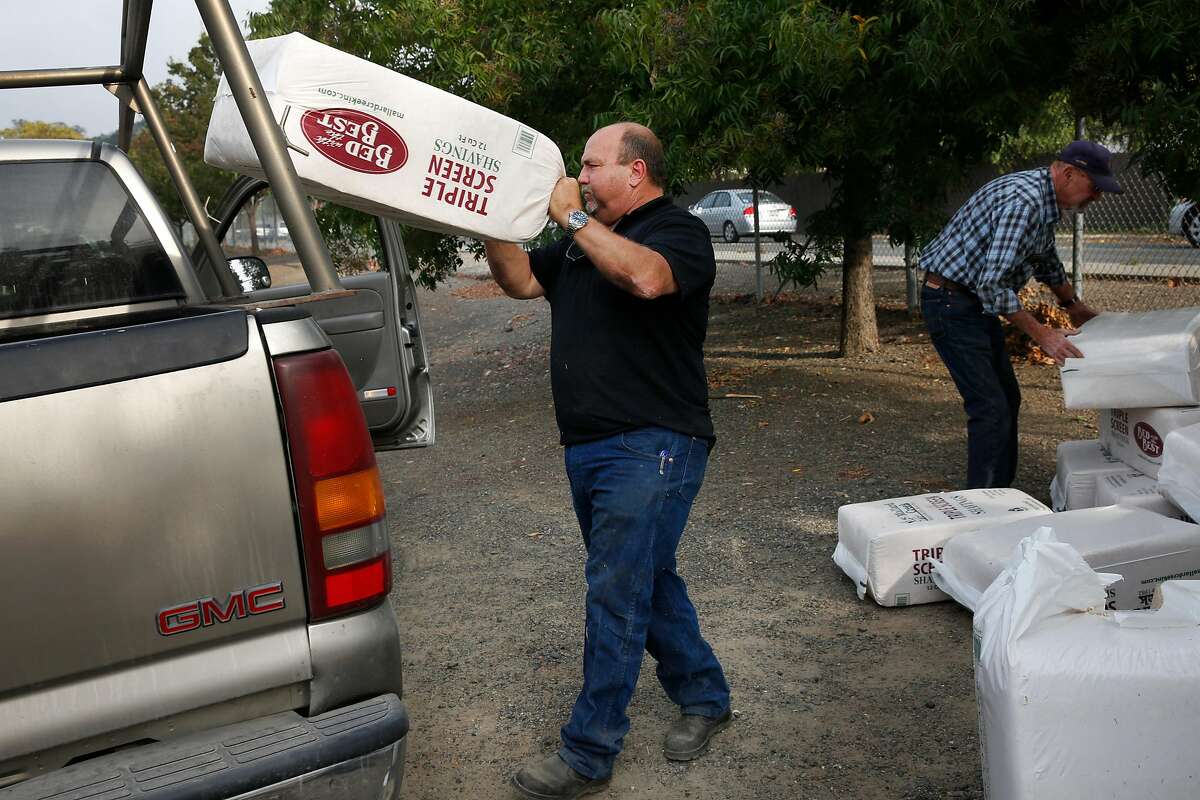 George Marinkovich, left, and Don Hendrix load donated shavings into a truck for their evacuated horses in the stables at the Santa Rosa Fairgrounds Oct. 10, 2017 in Santa Rosa, Calif. The stables were being used as a place for owners to house their evacuated large animals, like horses.