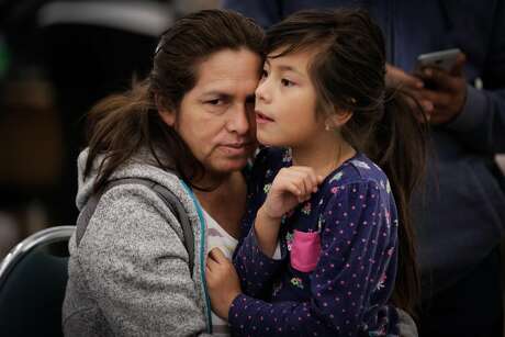 (l-r) Evacuees Marisela Mata embraces her daughter Marta Mata, 7, at a makeshift evacuation center after fires tore through Santa Rosa and Napa at the Petaluma Community Center in Petaluma, Calif., on Tuesday, Oct. 10, 2017.