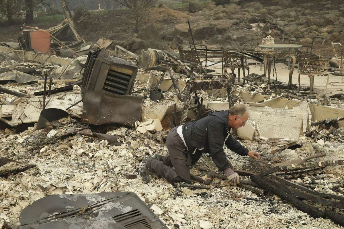 Chuck Rippey searches through the remains of his parents home in Napa, Calif., Oct. 10, 2017. Their parents, Charlie, 100, and Sara Rippey, 99, were killed in the wildfire at their home. (Jim Wilson/The New York Times)
