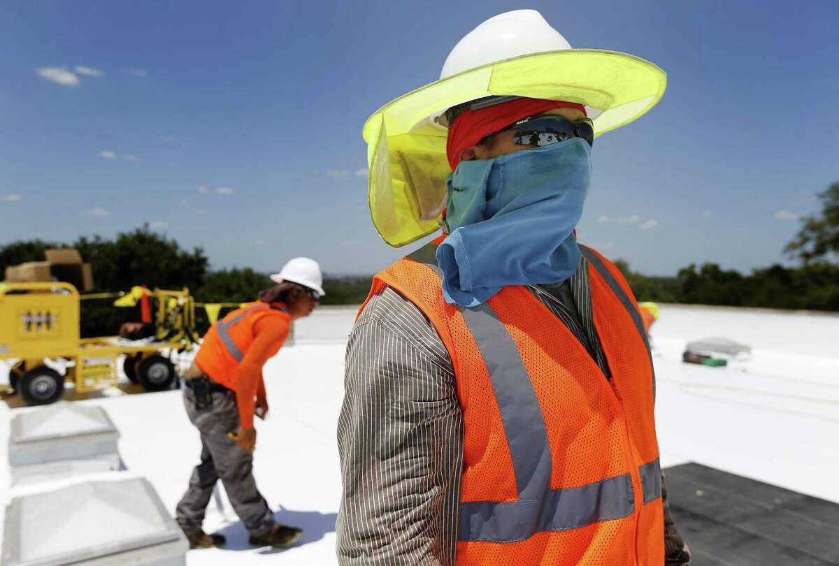Isaac Cruz Saucedo protects himself from extreme sun exposure as Beldon Roofing workers take on a job at Sunshine Cottage during the heat of the day in 2017. When climate scientists look at how global warming will change San Antonio, one clear signal emerges: An already-hot city is going to get hotter. By 2040 to 2060, nearly every day of an average July or August will be above 100 degrees, according to one computer model.