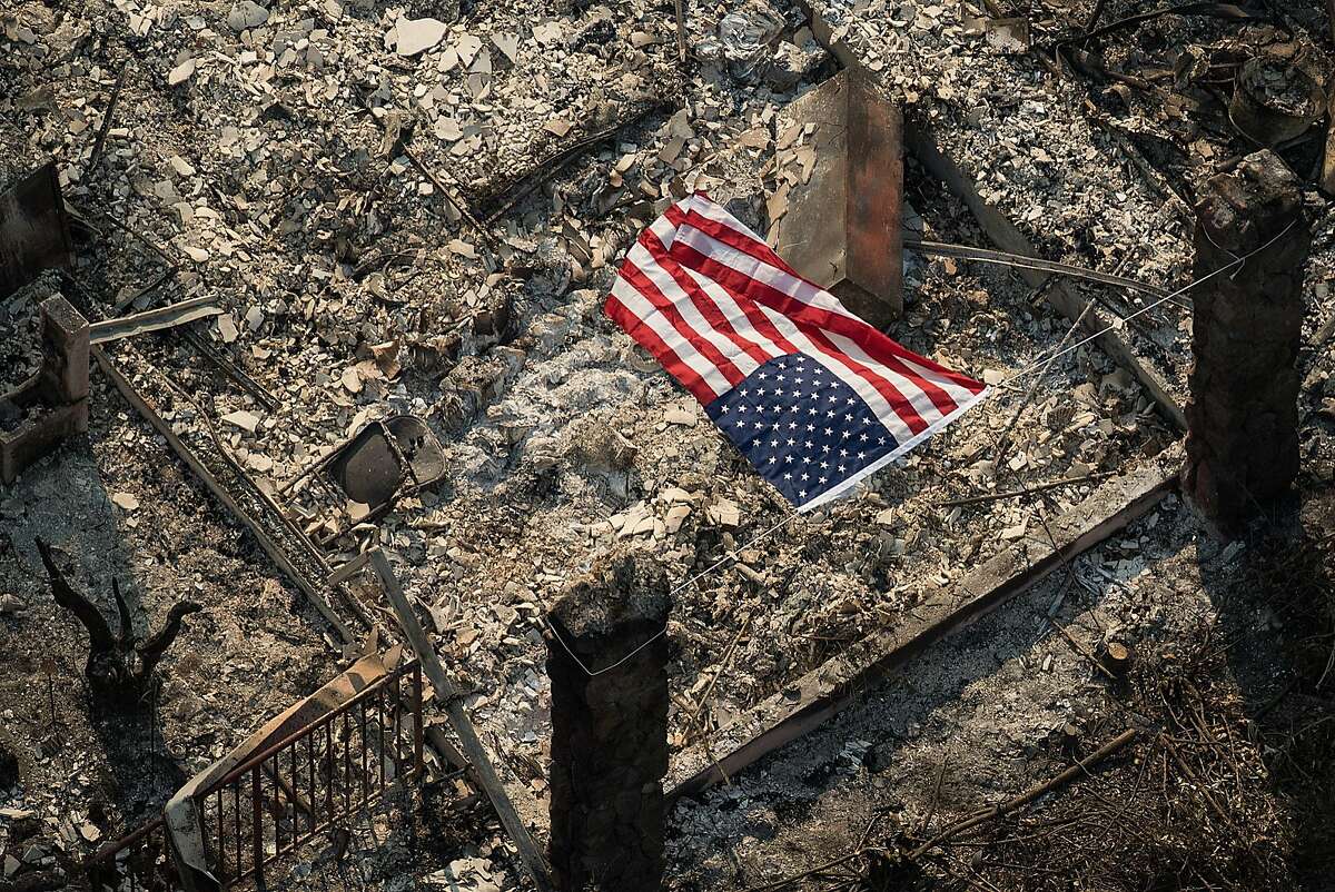 An American flag flies over the remains of a Coffey Park home following the Tubbs fire in Santa Rosa on Oct. 11, 2017.